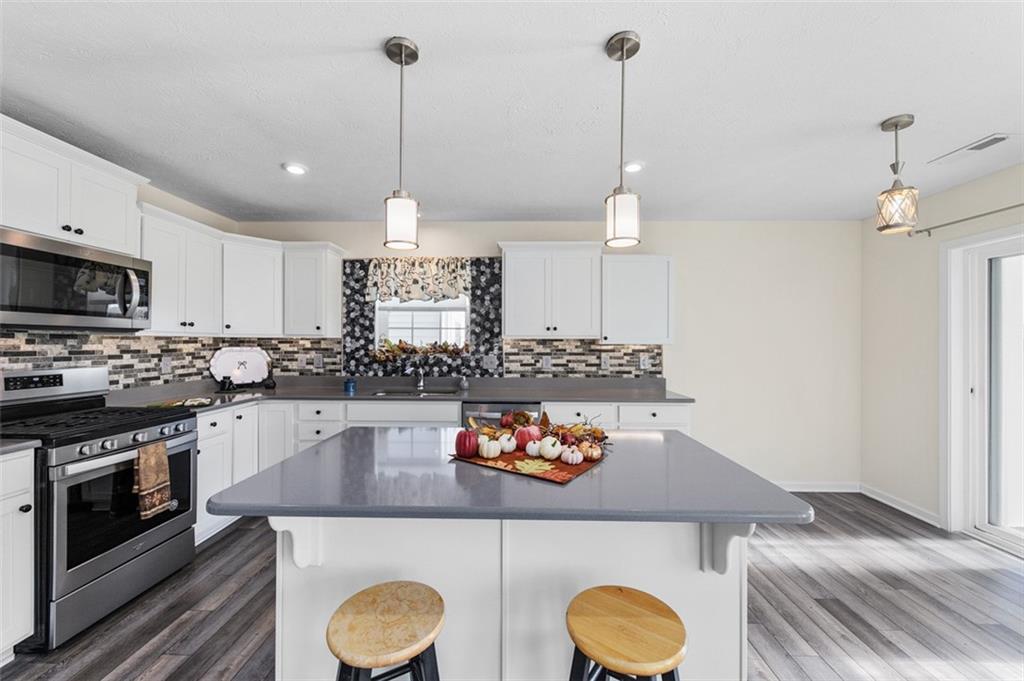 1024 Colonial Drive Uniontown, PA 15401 - Photo 8 of 33 a kitchen with stainless steel appliances granite countertop a sink a stove and a wooden floors