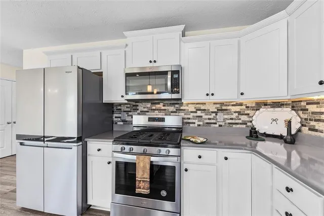 a kitchen with granite countertop a sink stove and refrigerator