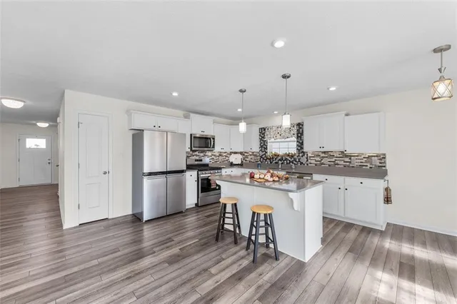 a kitchen with white cabinets and stainless steel appliances