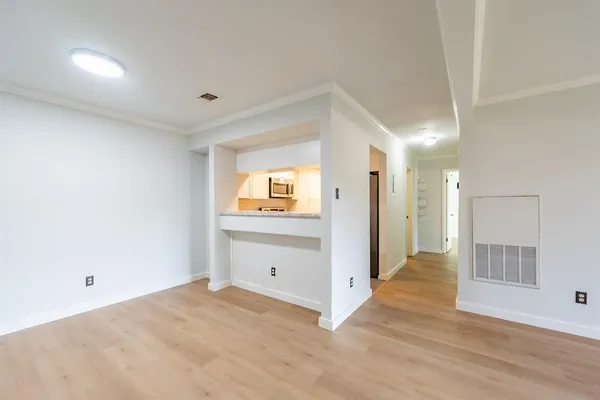 a view of empty room with wooden floor