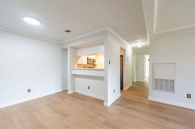 a view of empty room with wooden floor