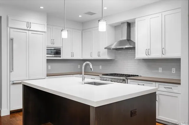 a kitchen with stainless steel appliances a sink a stove a refrigerator and cabinets