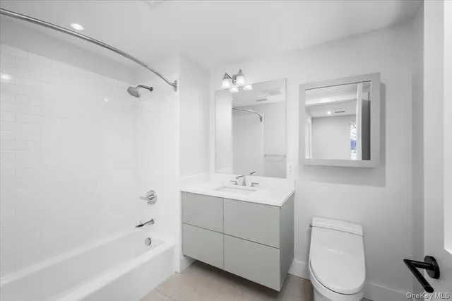 a bathroom with a toilet a sink a mirror and a bathtub