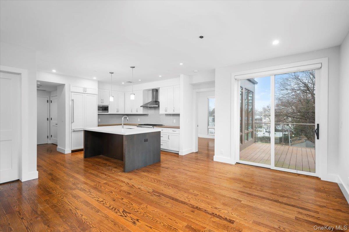 422 East Boston Post Road, Unit 303 Mamaroneck, NY 10543 - Photo 7 of 23 a large kitchen with a center island wooden floor stainless steel appliances and a window