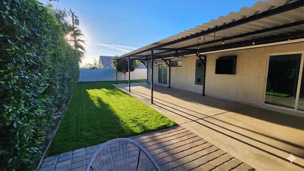 a view of a house with backyard and sitting area