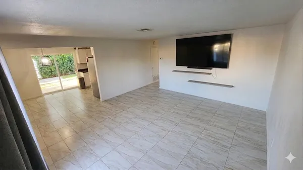 a view of a living room with a flat screen tv and floor to ceiling window