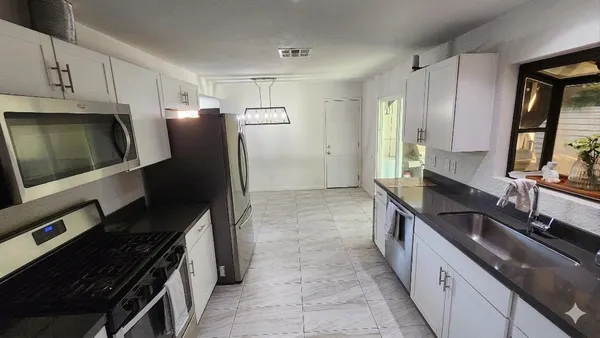 a kitchen with stainless steel appliances a sink stove and refrigerator