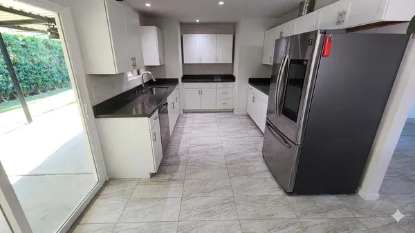 a kitchen with granite countertop a refrigerator and a sink