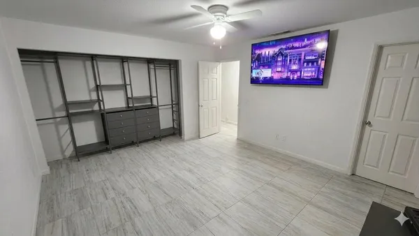 a bedroom with a bed and a ceiling fan