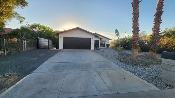 a front view of house with yard and trees