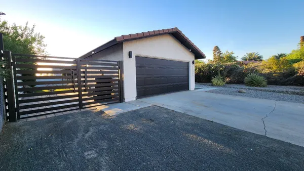 a view of backyard and wooden fence