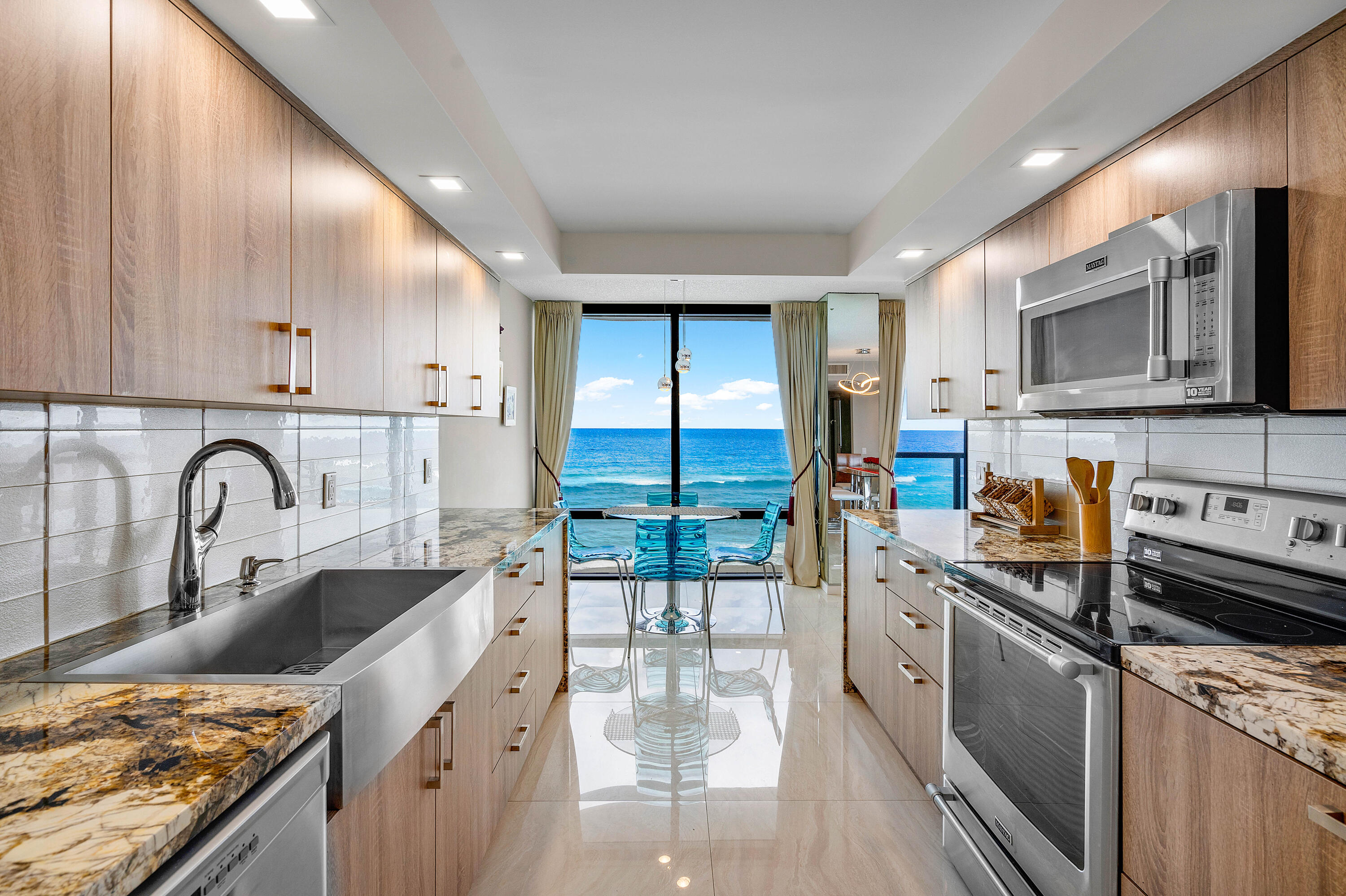 250 South Ocean Boulevard, Unit 7E Boca Raton, FL 33432 - Photo 16 of 45 a kitchen with stainless steel appliances granite countertop a stove top oven a sink a counter space and cabinets