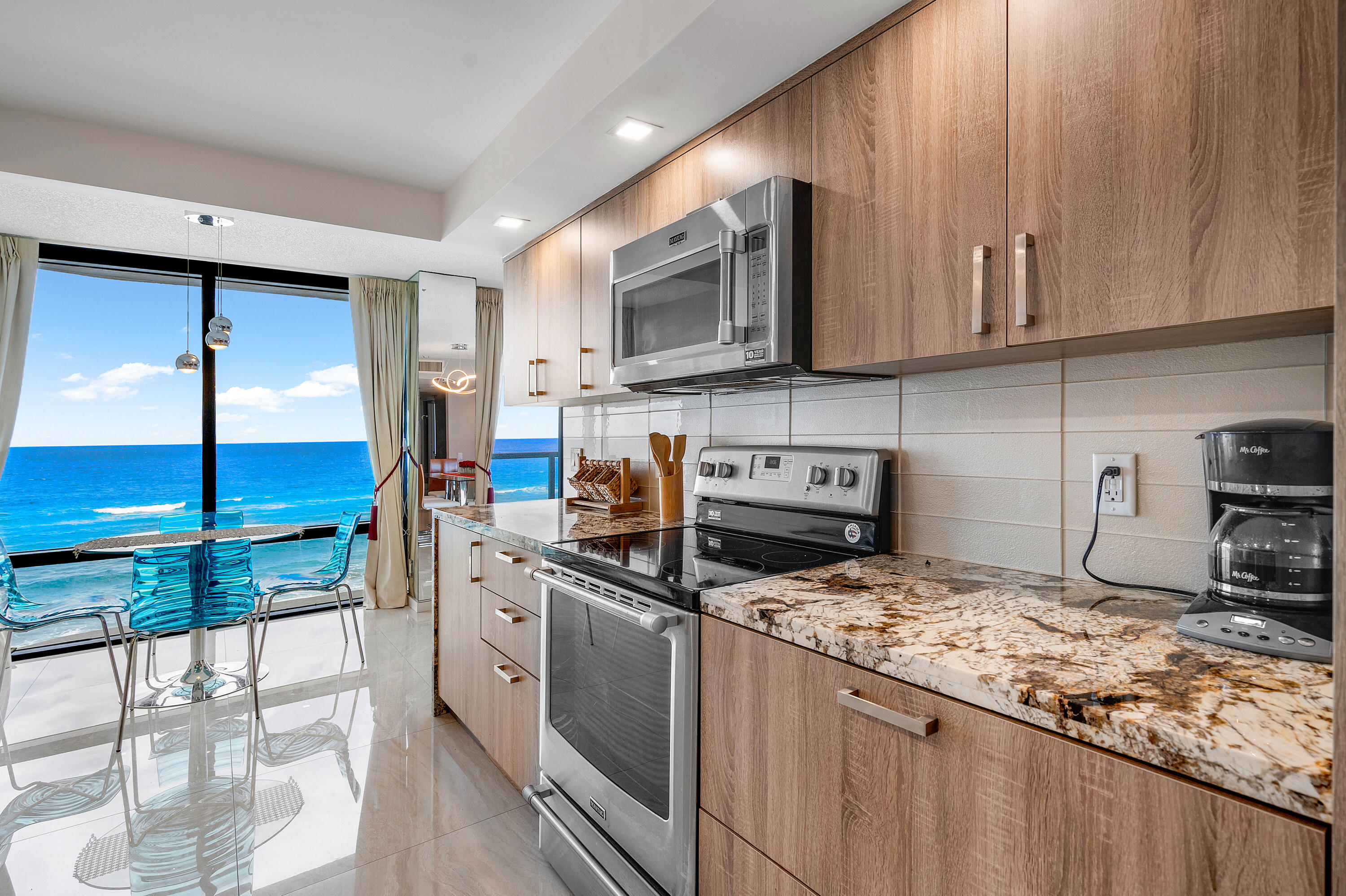 250 South Ocean Boulevard, Unit 7E Boca Raton, FL 33432 - Photo 19 of 45 a kitchen with stainless steel appliances granite countertop a stove a sink and a microwave