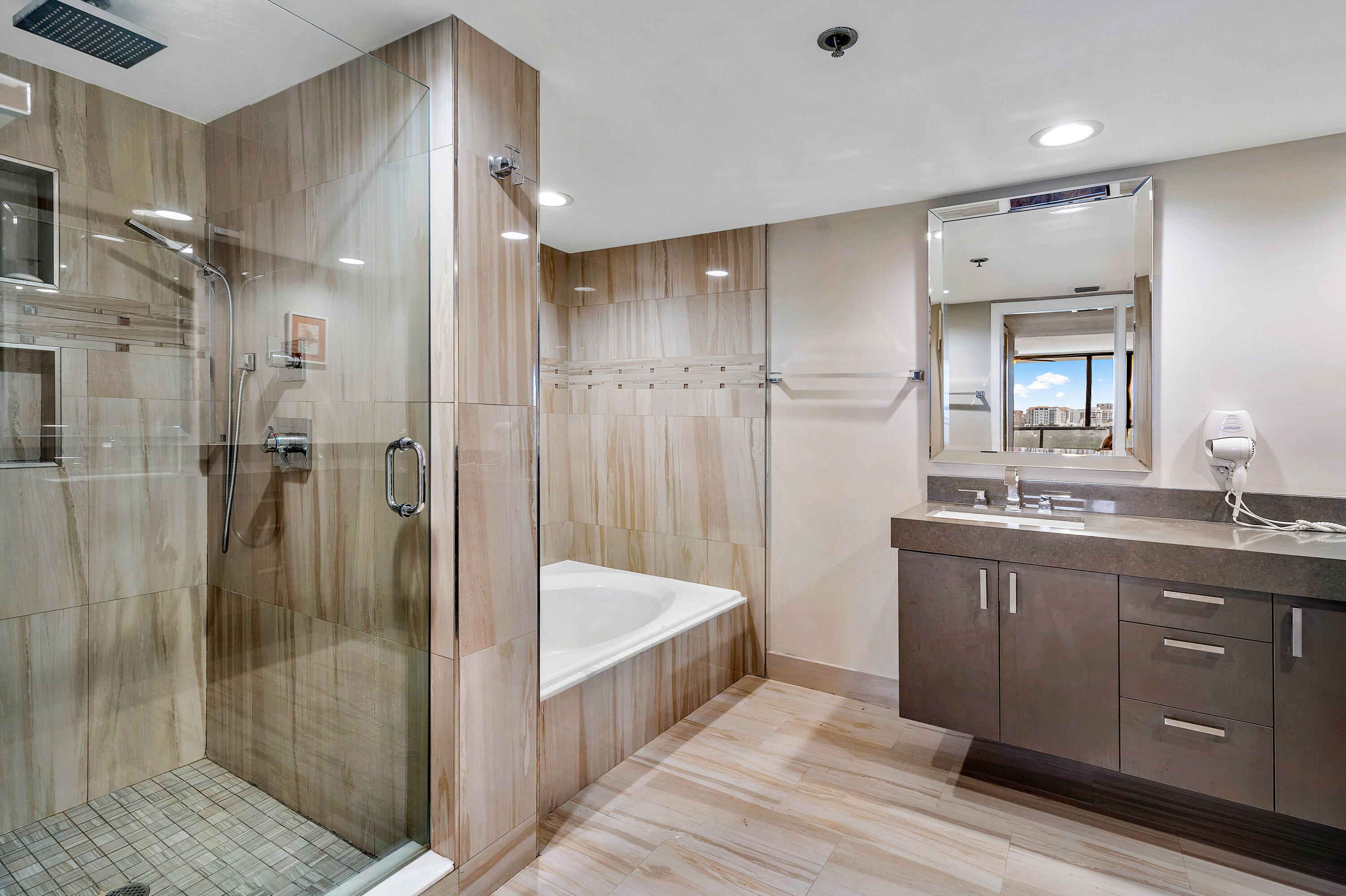 250 South Ocean Boulevard, Unit 7E Boca Raton, FL 33432 - Photo 27 of 45 a bathroom with a double vanity sink a large mirror and shower