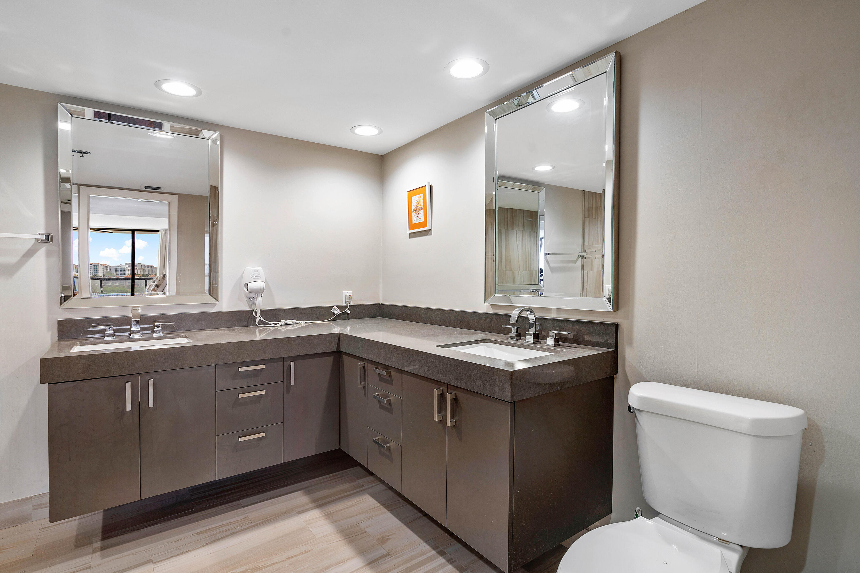 250 South Ocean Boulevard, Unit 7E Boca Raton, FL 33432 - Photo 28 of 45 a bathroom with a toilet sink and mirror