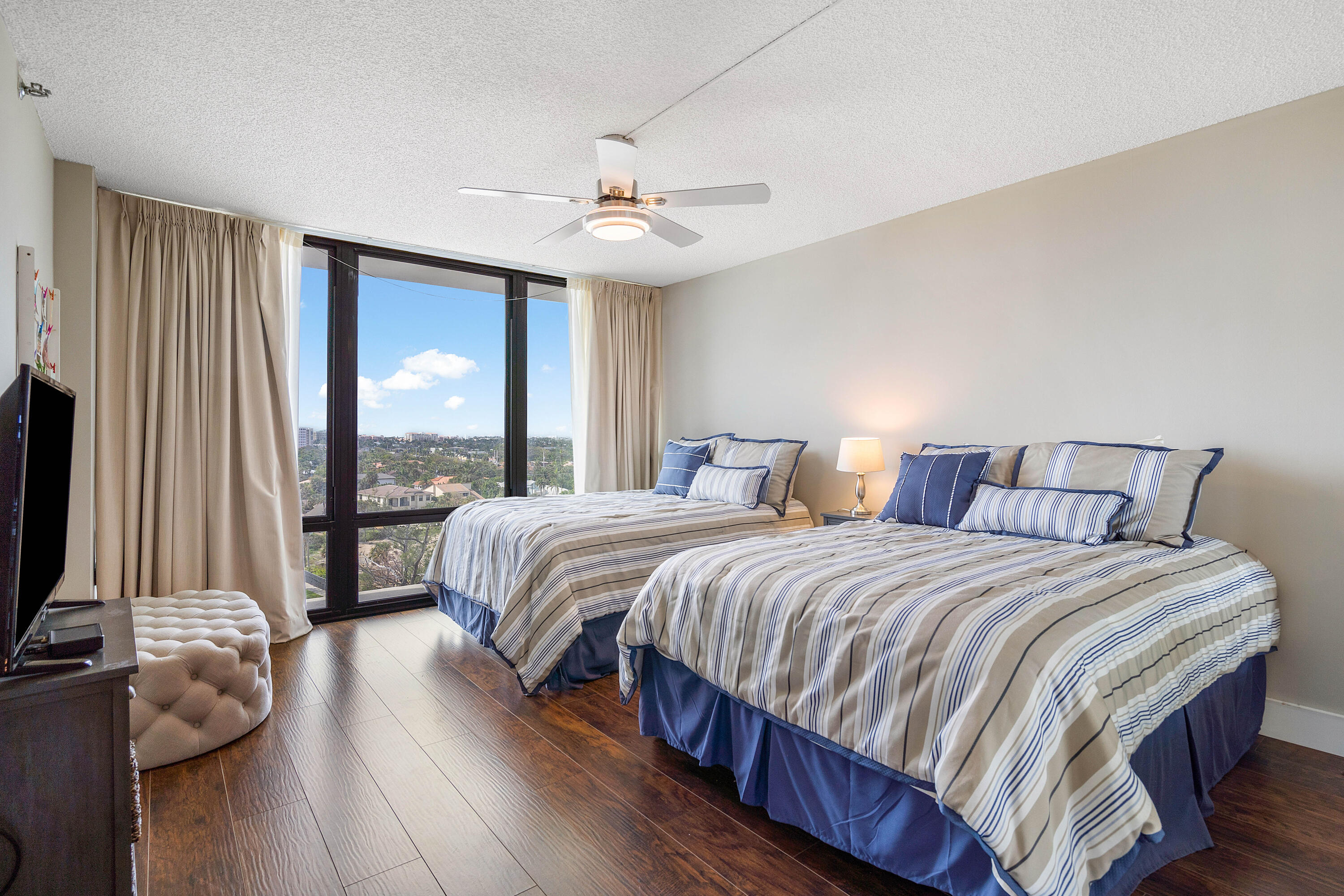 250 South Ocean Boulevard, Unit 7E Boca Raton, FL 33432 - Photo 30 of 45 a bedroom with a large bed and a flat tv screen on dresser