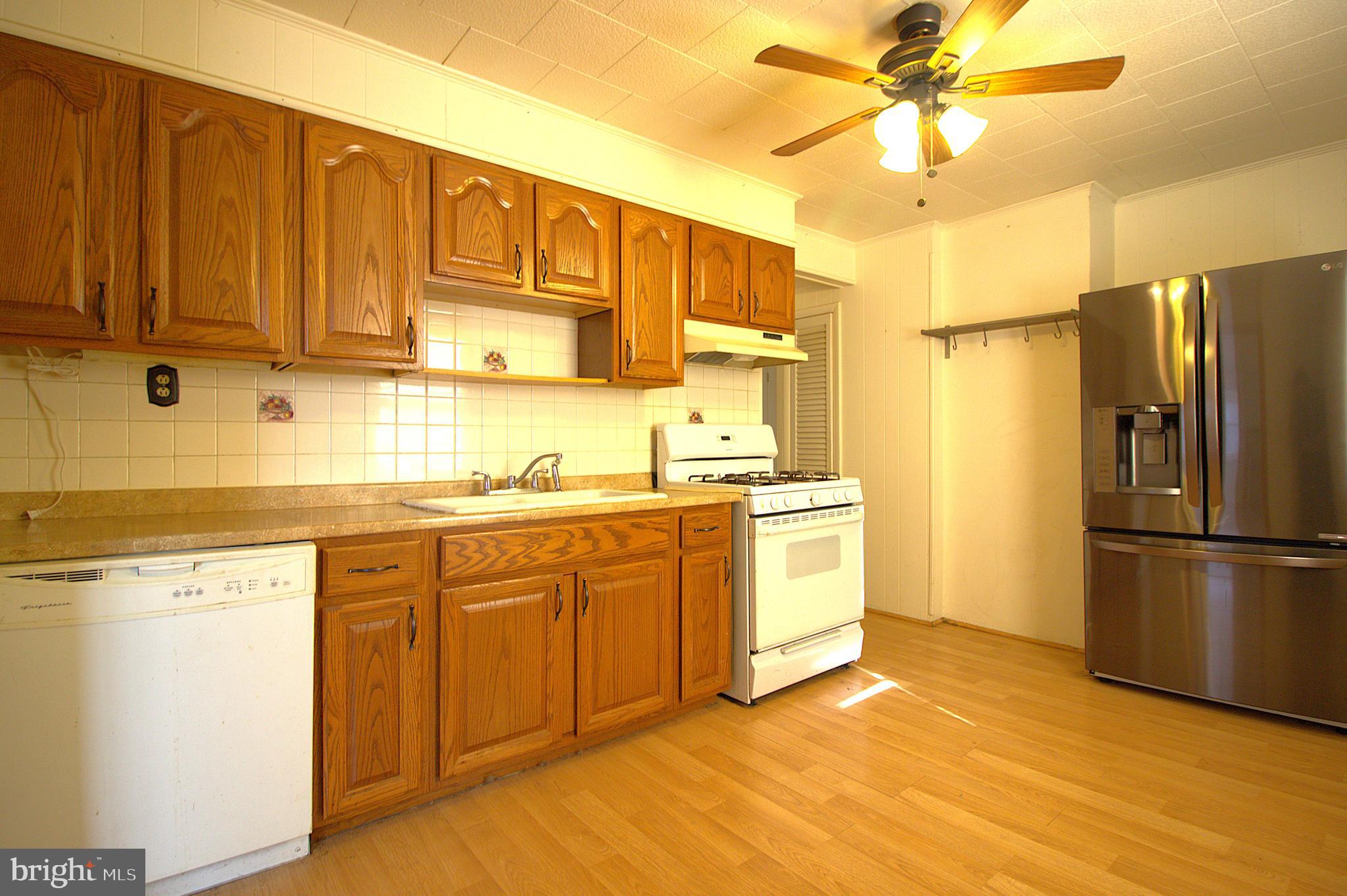 7613 Maple Road Baltimore, MD 21222 - Photo 12 of 32 a kitchen with a refrigerator sink and cabinets