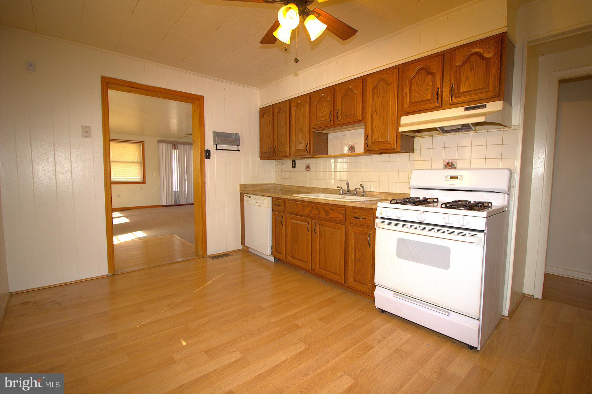 7613 Maple Road Baltimore, MD 21222 - Photo 13 of 32 a kitchen with stainless steel appliances granite countertop a stove a sink and a refrigerator