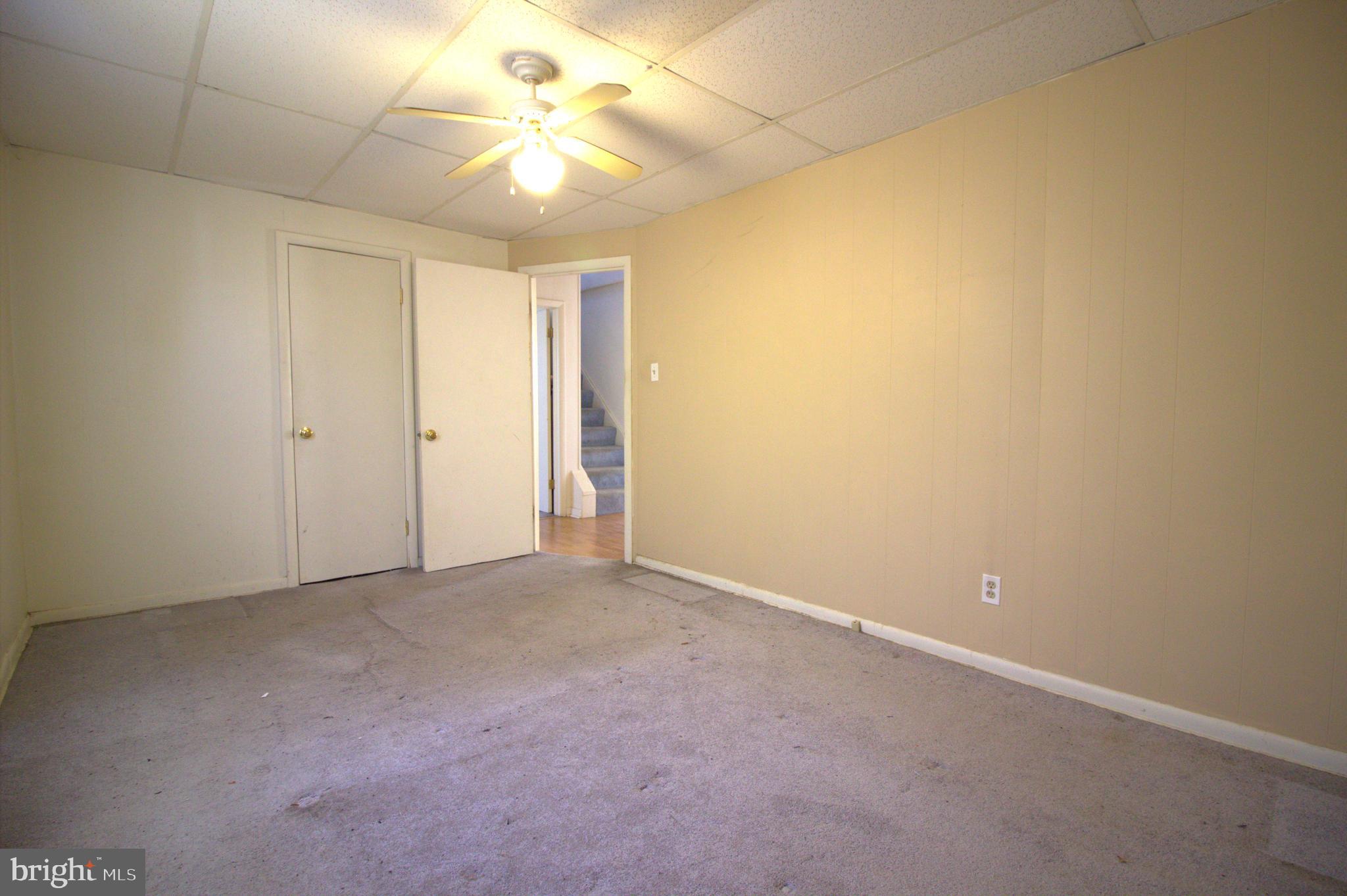 7613 Maple Road Baltimore, MD 21222 - Photo 10 of 32 an empty room with a ceiling fan and carpet