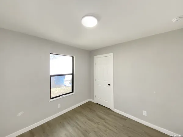 an empty room with windows and closet