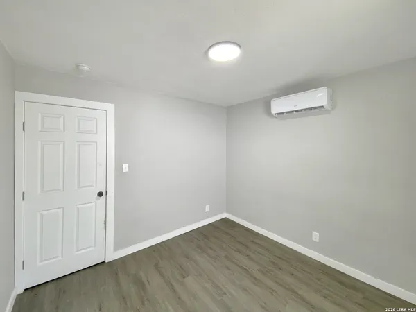 a view of an empty room with wooden floor