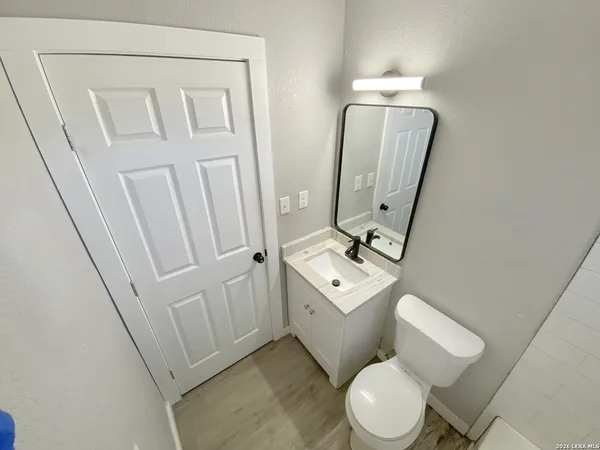 a bathroom with a toilet sink and mirror