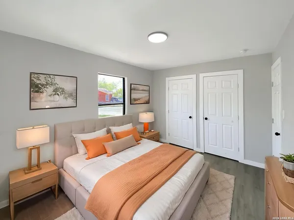 a bedroom with a bed and a lamp on dresser