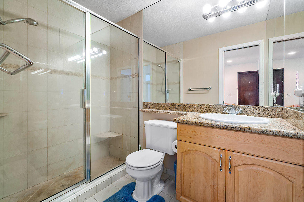 10921 Gable Street Boca Raton, FL 33428 - Photo 12 of 28 a bathroom with a granite countertop sink toilet and shower