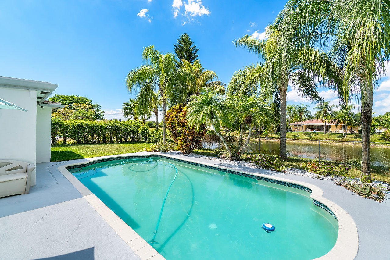 10921 Gable Street Boca Raton, FL 33428 - Photo 16 of 28 a view of a swimming pool with a yard