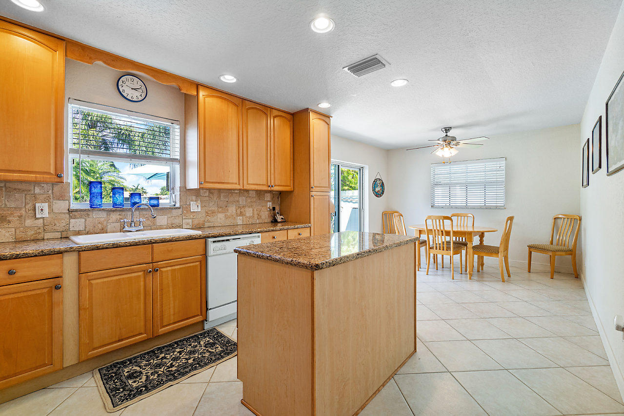 10921 Gable Street Boca Raton, FL 33428 - Photo 3 of 28 a kitchen with stainless steel appliances granite countertop a stove a sink and a refrigerator