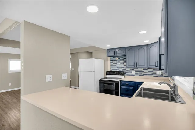 a kitchen with kitchen island sink stove and refrigerator