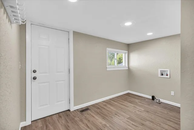 a view of empty room with wooden floor