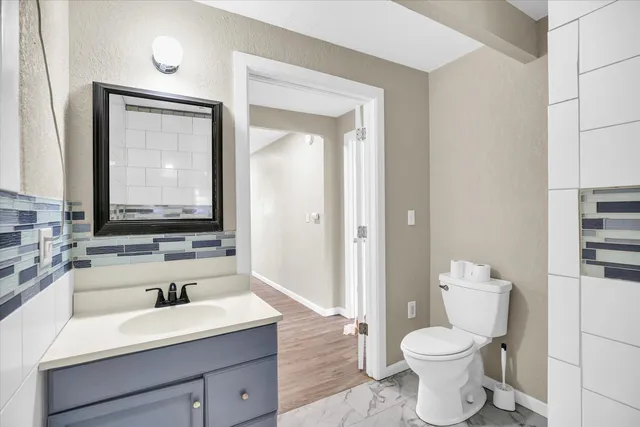 a bathroom with a toilet a sink and a large mirror