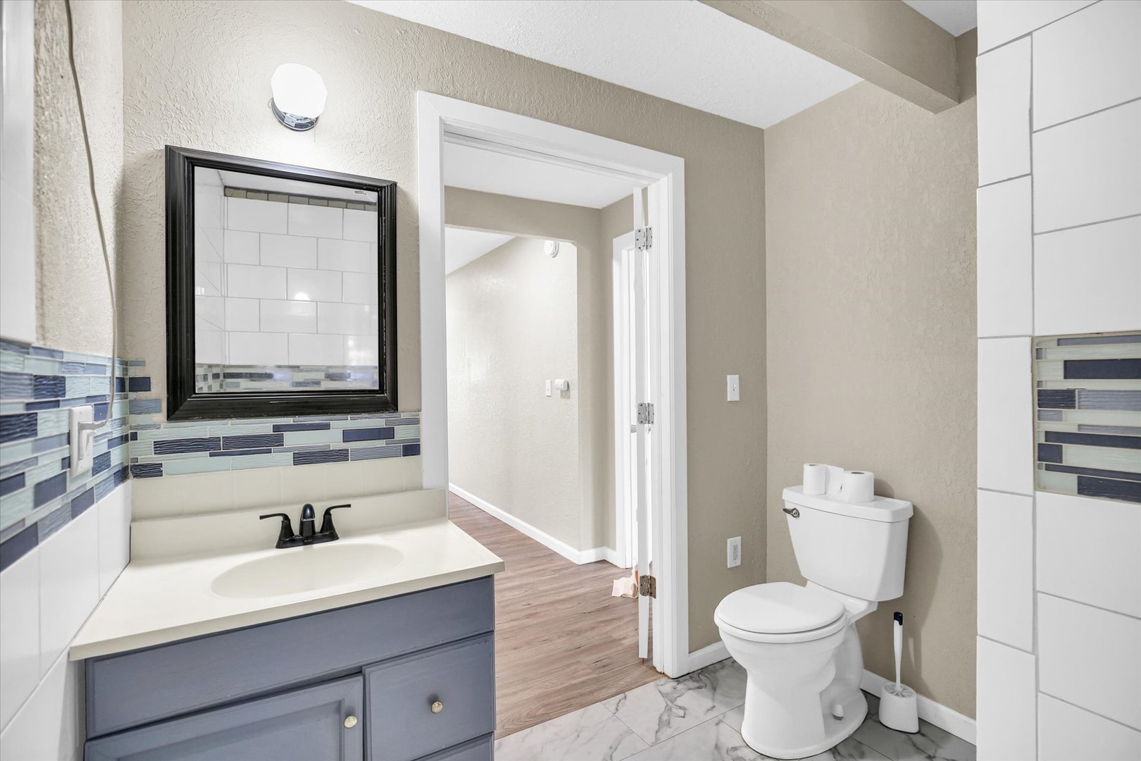 703 South Spruce Street Villa Grove, IL 61956 - Photo 7 of 28 a bathroom with a toilet a sink and a large mirror