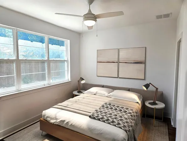 a living room with furniture kitchen view and a large window