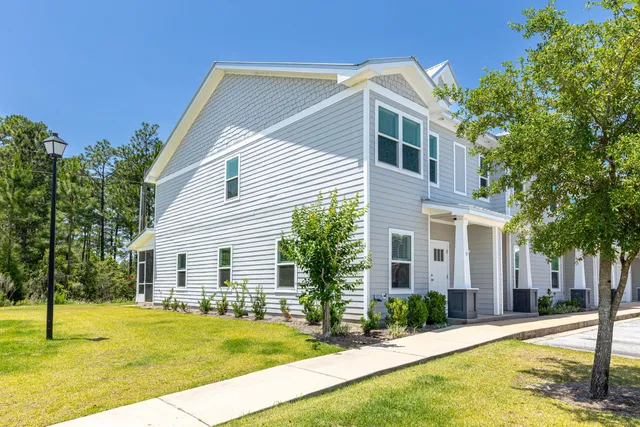 a front view of house with yard and trees around