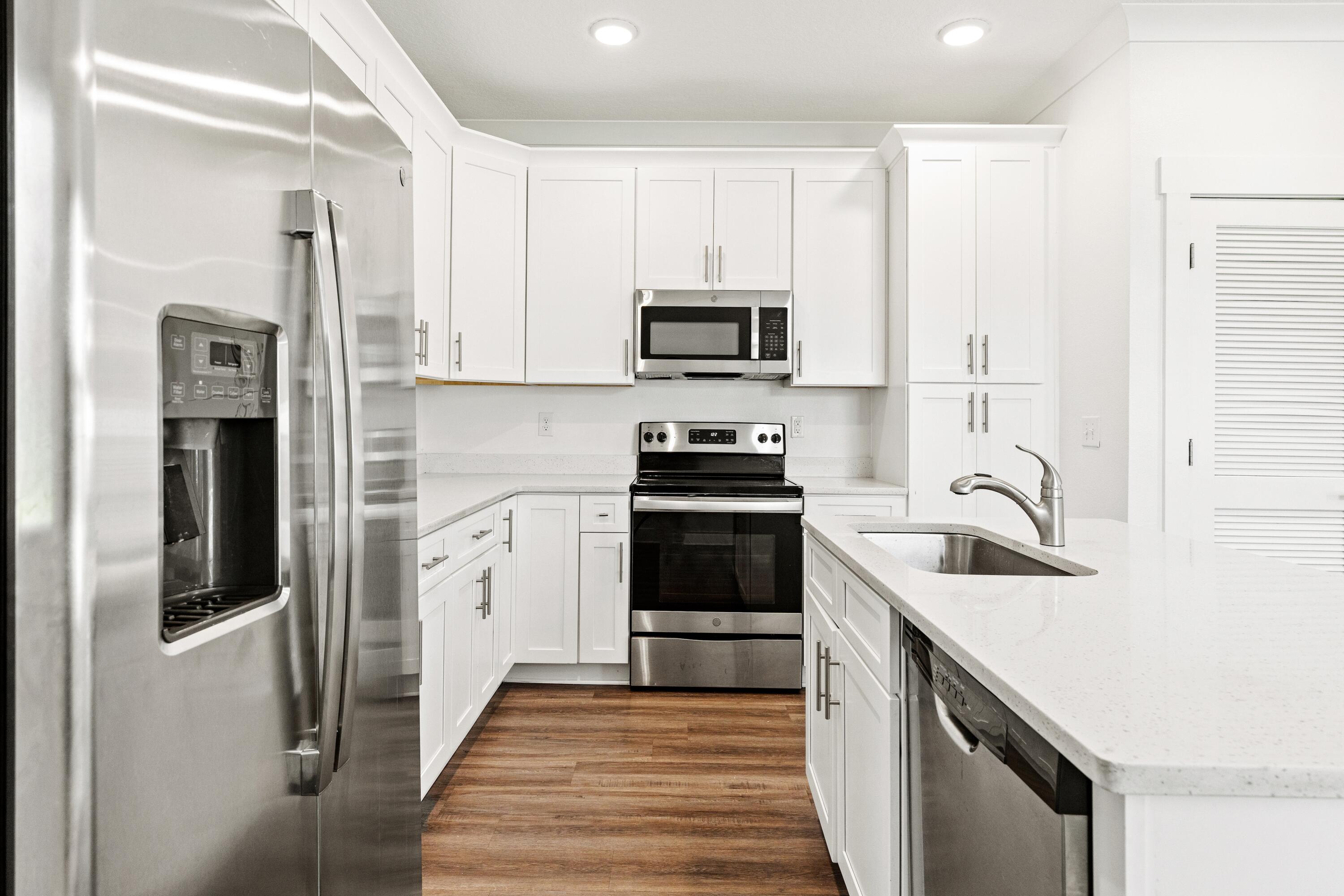 392 North Sand Palm Road Freeport, FL 32439 - Photo 3 of 36 a kitchen with white cabinets and stainless steel appliances