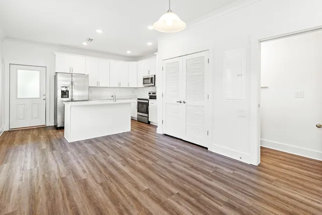 a view of a kitchen with wooden floor and a window