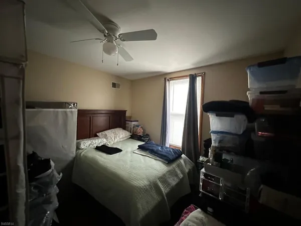 a bedroom with a bed and a ceiling fan