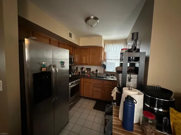 a kitchen with a refrigerator and a stove top oven