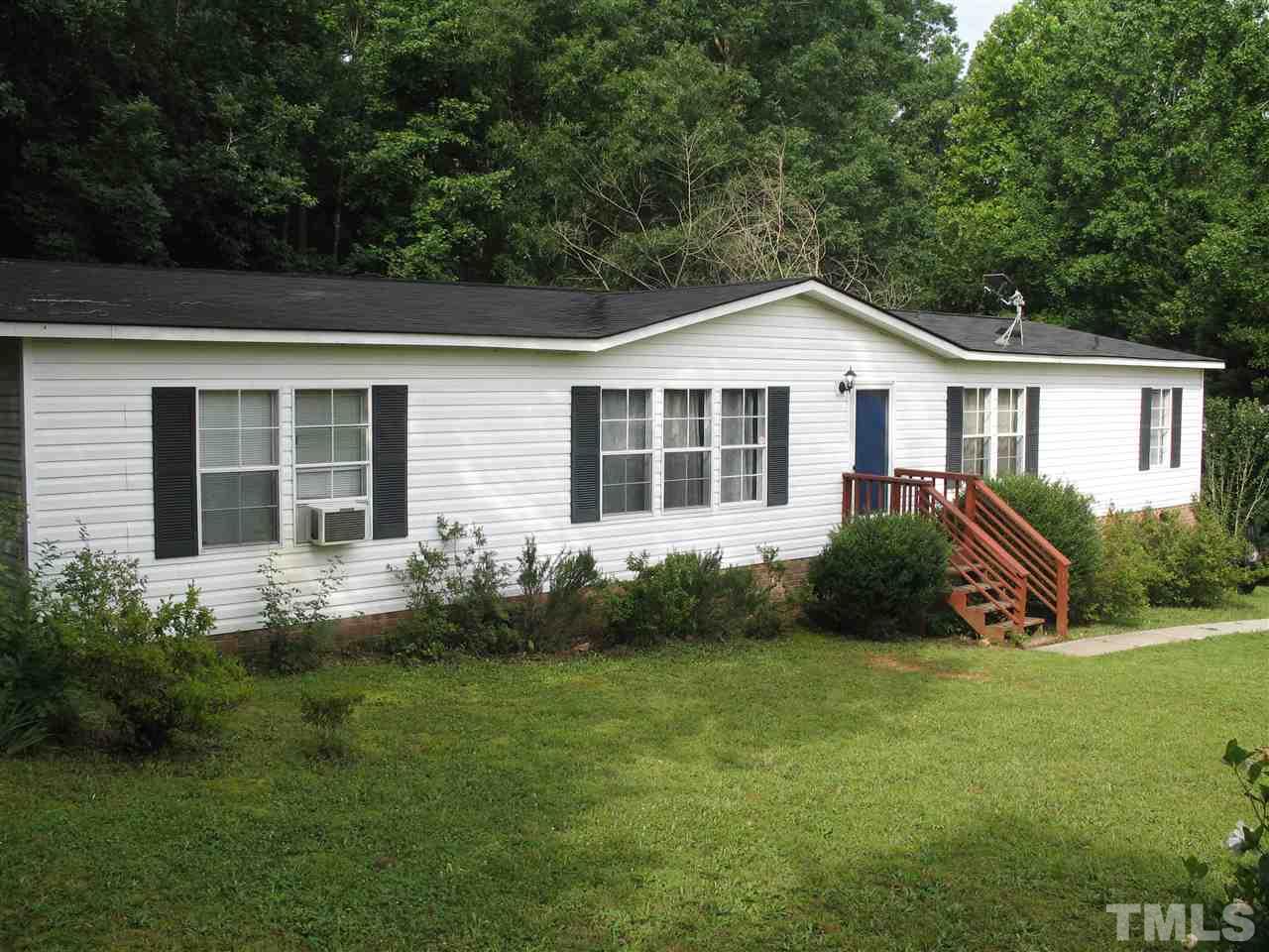 a front view of a house with a garden and yard
