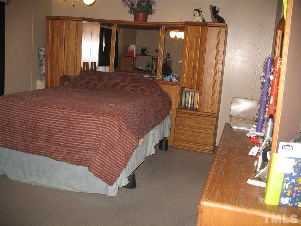 145 Ridgewood Drive Middlesex, NC 27557 - Photo 14 of 20 a spacious bedroom with a bed a mirror and lamp