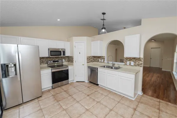 a kitchen with white cabinets and stainless steel appliances