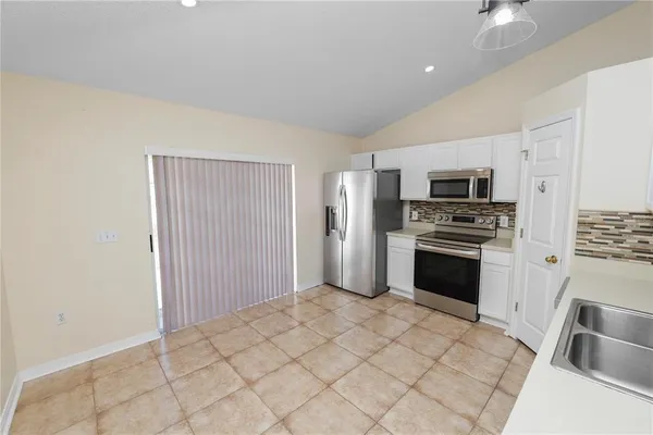 a kitchen with granite countertop a refrigerator and a stove top oven