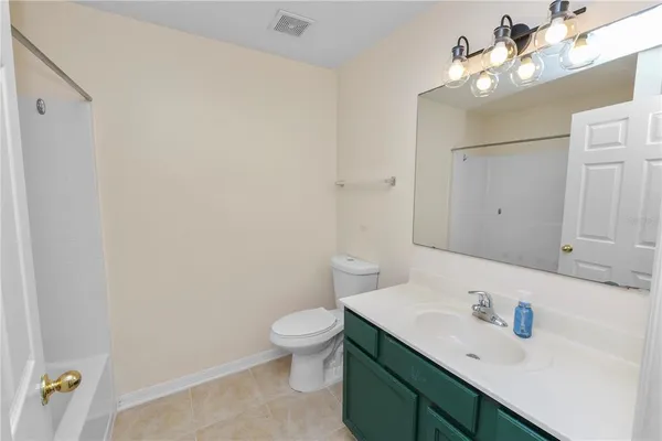 a bathroom with a sink vanity mirror and toilet