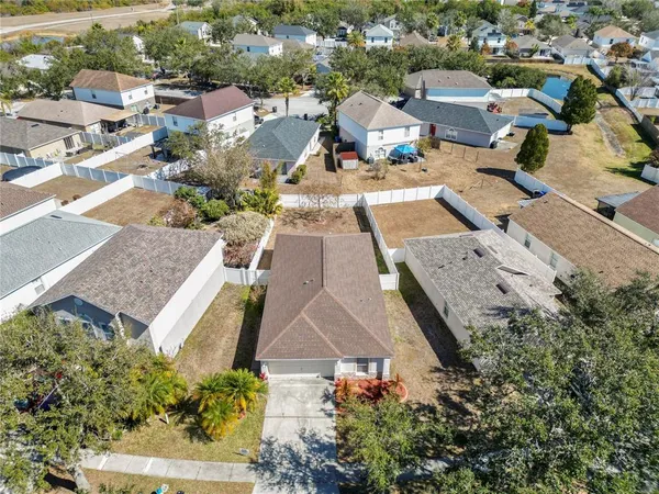 an aerial view of a house with yard and parking space