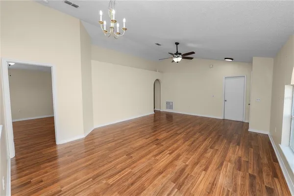 wooden floor in an empty room with a chandelier