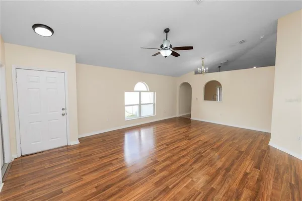 a view of a room with wooden floor and ceiling fan