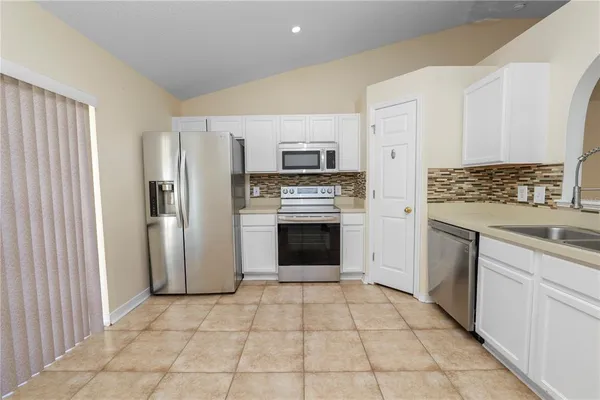 a kitchen with a stove top oven and refrigerator