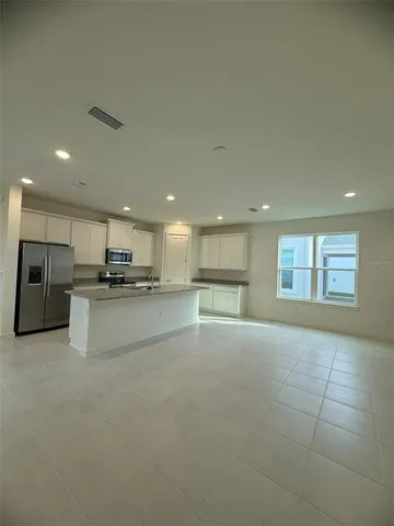 a view of kitchen with kitchen island and stainless steel appliances